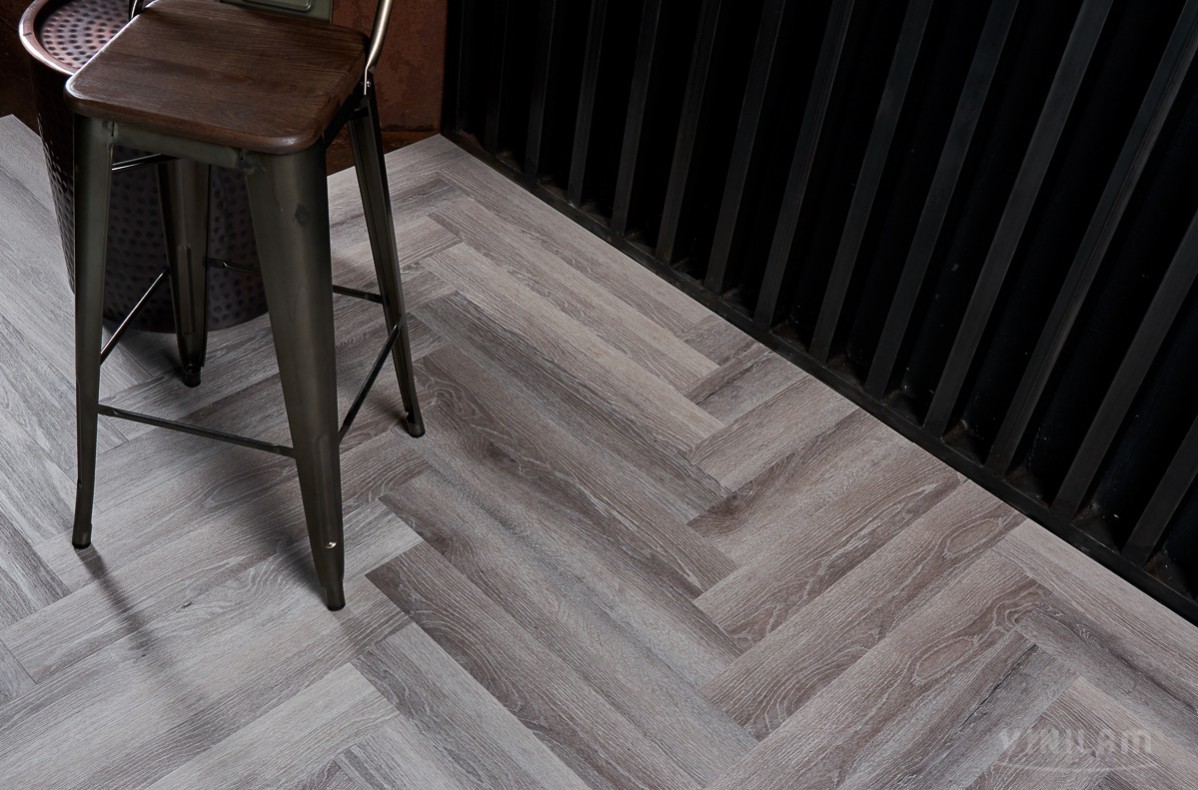 Кварцвиниловый SPC ламинат Vinilam Parquet Herringbone Паркет Микеланджело IS11144 венгерская елка 720×120×6,5 фото в интерьере