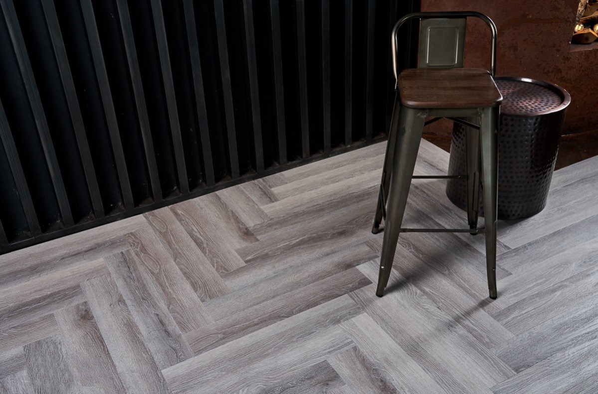 Кварцвиниловый SPC ламинат Vinilam Parquet Herringbone Паркет Микеланджело IS11144 венгерская елка 720×120×6,5 фото в интерьере