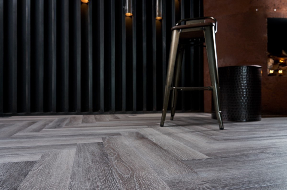 Кварцвиниловый SPC ламинат Vinilam Parquet Herringbone Паркет Микеланджело IS11144 венгерская елка 720×120×6,5 фото в интерьере