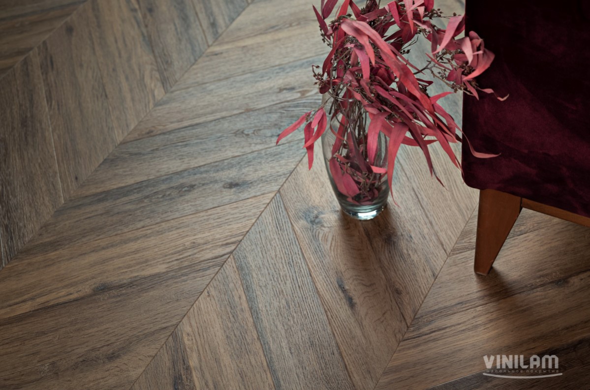 Кварцвиниловый SPC ламинат Vinilam Parquet Chevron Шеврон Лувр I107516 французская елка 1293×305×8,5 фото в интерьере